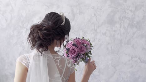 cámara lenta vista trasera novia morena sostiene un ramo de rosas