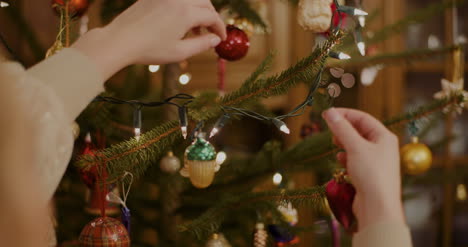 mujer joven decorando el árbol de navidad en casa 1