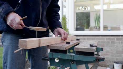 a man measuring a piece of wood