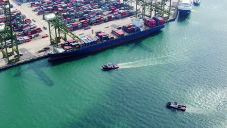 aerial footage of boats approaching a commercial port terminal in singapore