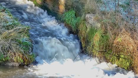 Wasser,-Das-Eine-Schleuse-An-Einem-Kanal-Herunterläuft-Und-Am-Grund-Schäumt