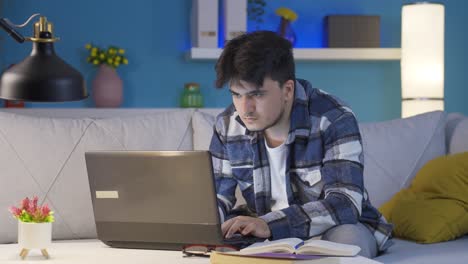 Man-focusing-on-computer-has-serious-expression.-At-home-at-night.