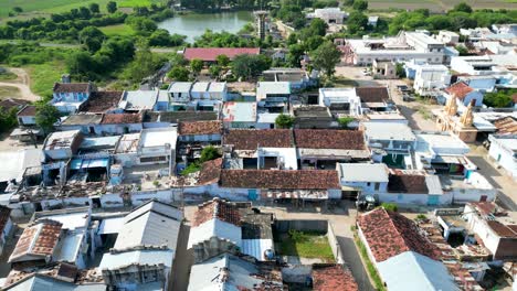 small indian village drone shot, with old houses and temple with lake, rural india, country side