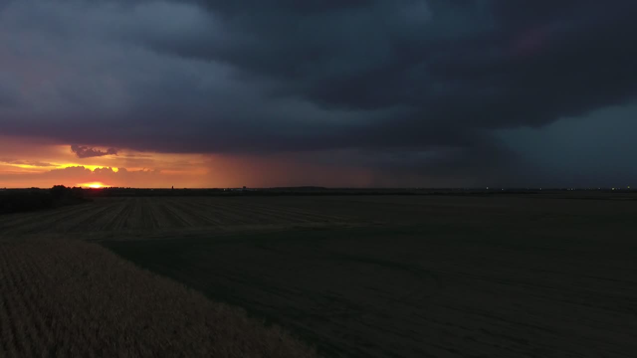 vuelo sobre un campo al atardecer durante una tormenta