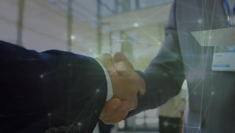 Animation-of-network-of-connections-over-mid-section-of-two-businessmen-shaking-hands-at-office