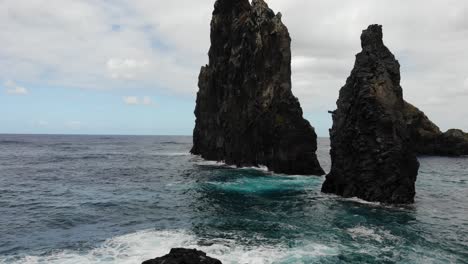 El-Dron-Captura-La-Belleza-Escarpada-De-Las-Rocas-De-Ribeira-Da-Janela,-Mostrando-Su-Imponente-Presencia-En-Medio-Del-Esplendor-Natural-De-La-Isla-De-Madeira.