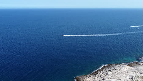 boats sailing across mediterranean sea near port' alga in polignano a mare in italy