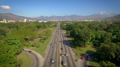 drone view of a highway in valencia, carabobo, venezuela, next to a green park