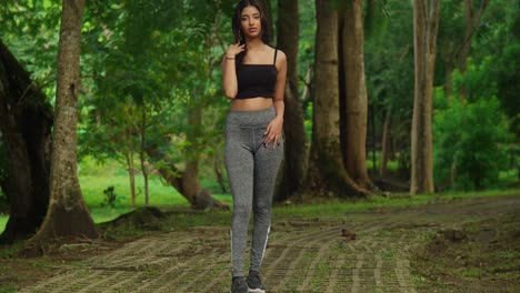 engaged in physical activity, a young girl donned in sports wear enjoys her workout session amidst the lush surroundings of a tropical park