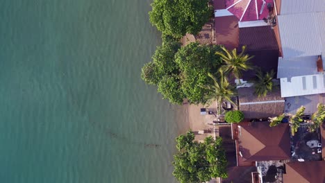 great aerial top view flight beach village huts resort, tropical bungalows on mountainous island thailand 2022