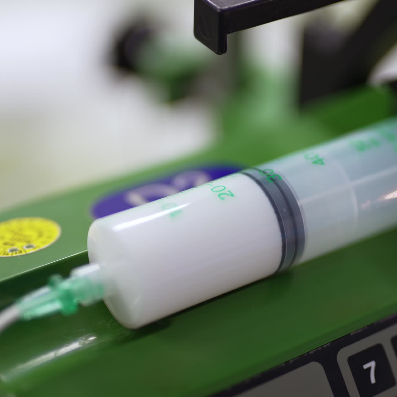 Syringe with medicines attached to an equipment and tube. Equipment working at surgery room during operation. Close up
