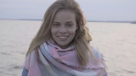 face portrait of attractive happy woman standing at background sunset above sea