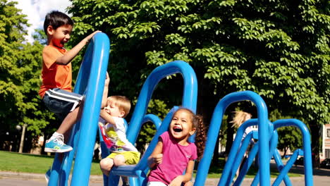 happy children playing on a blue climbing structure in a park