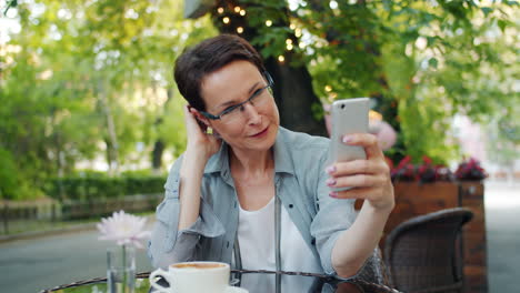 mujer usando un teléfono inteligente en un café