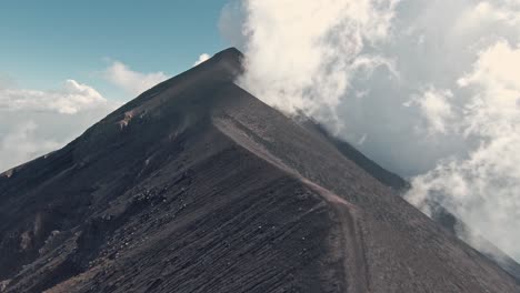 steep ridges of fuego volcano slopes and peak, aerial fpv flying upwards