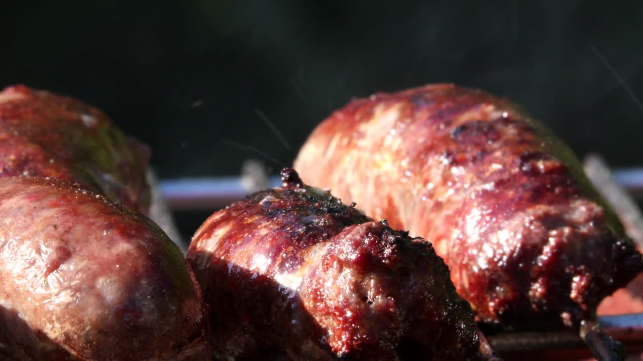 salchichas que chisporrotean en la barbacoa, primer plano