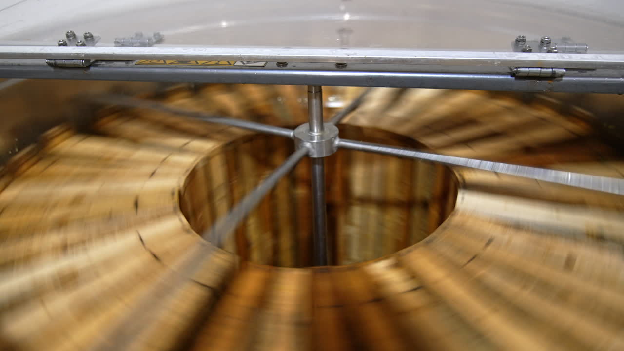 Electric machine for honey removal rotating frames. Close up. Honey extractor working with opened lid. Top view.