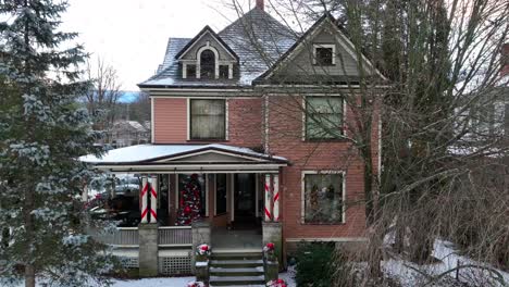 slow aerial rising shot of victorian home decorated for christmas