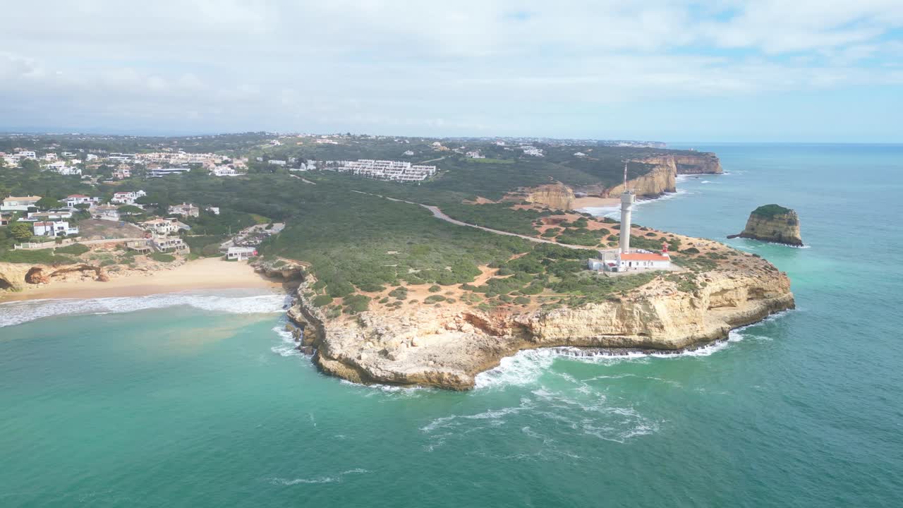 Scenic aerial view of Ferragudo coastline with lighthouse, beach, and ocean in Algarve