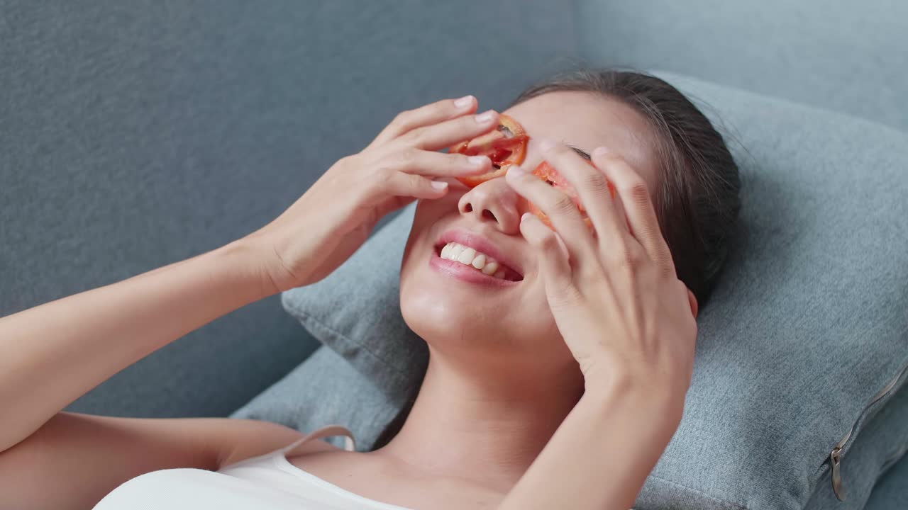 눈 에 토마토 조각 을 넣고 휴식을 취 하는 여자