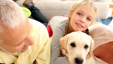 Glückliche-Familie-Spielt-Mit-Labrador-Welpen-Auf-Dem-Teppich