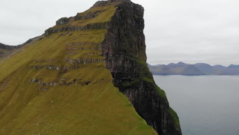 beautiful aerial parallax of incredible tall cliff in the ocean in the landscape of the faroe islands on a cloudy day