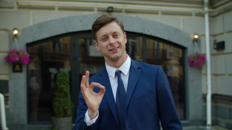 Portrait-of-confident-business-man-looking-at-camera-outdoors.-Man-showing-okay