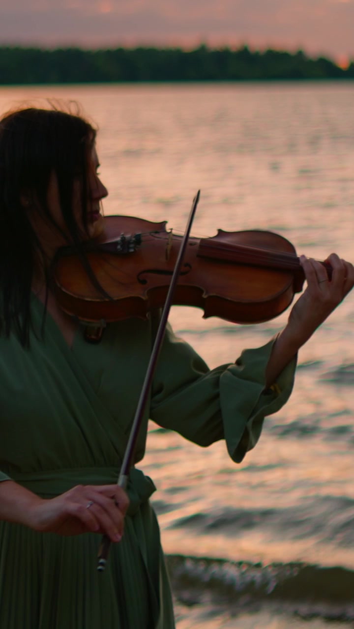 Woman Playing Violin by the Lake at Sunset