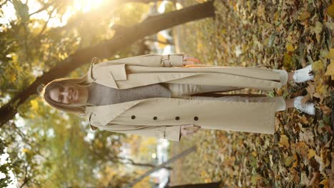 happy woman throwing leaves in autumn in slow motion, smiling, full length