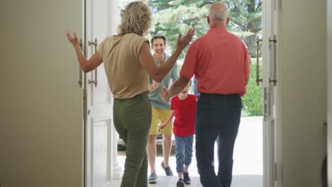 Felices-Abuelos-Caucásicos-Abriendo-La-Puerta-Y-Saludando-A-Su-Familia