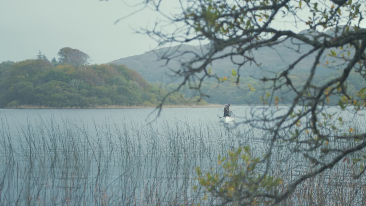 목가적인 낚시 장소 호수 보트에서 낚시하는 어부