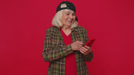 mujer de edad avanzada que utiliza el teléfono móvil escribiendo publicaciones en la web mensajes de texto navegando adicción a las redes sociales
