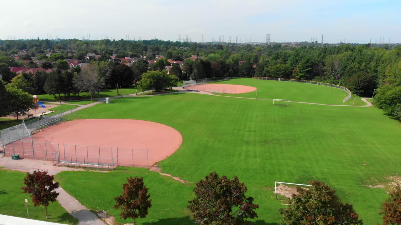Two Empty Residential Neighbourhood Baseball Diamonds and Soccer Pitch Slow Aerial Shot