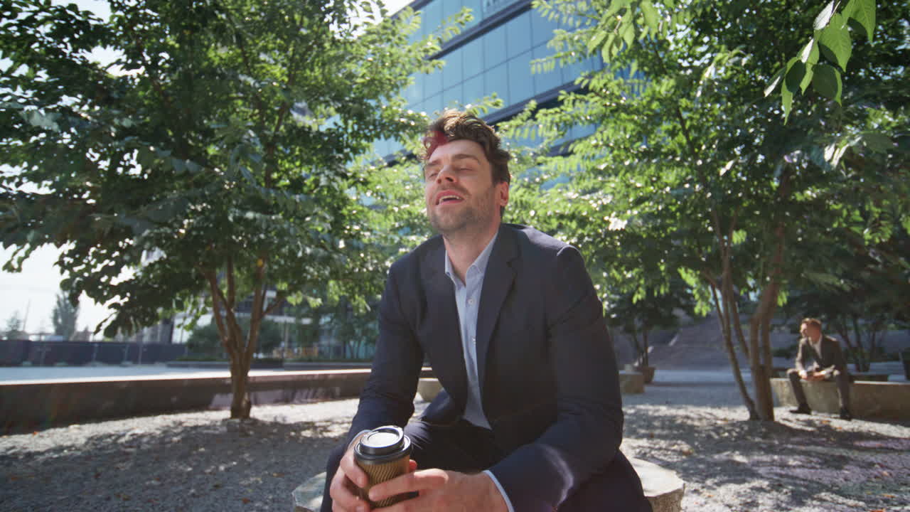 um gerente de escritório despreocupado a relaxar num parque verde e ensolarado no trabalho.