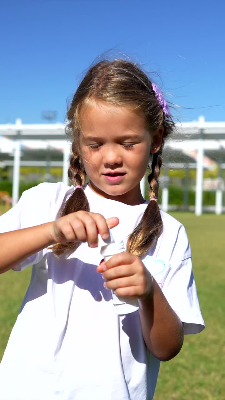 Uma menina soprando bolhas de sabão ao ar livre em um dia ensolarado