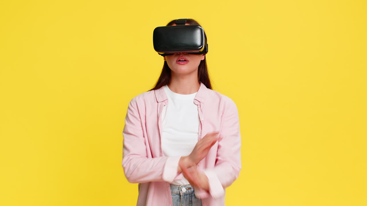 Donna con visore VR muove le mani in aria, eccitata e stupita dal mondo digitale immersivo della realtà virtuale.