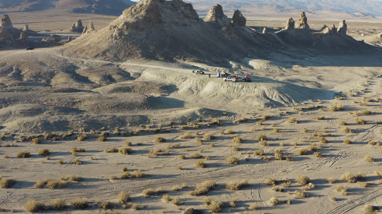 toma panorámica rápida de un camping frente a una cadena de pináculos que se elevan desde la cuenca del lago