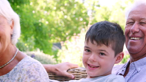 Familia-De-Tres-Generaciones-Relajándose-En-El-Jardín,-De-Cerca