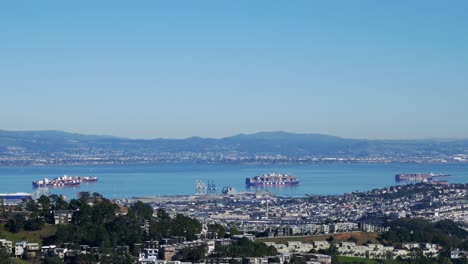 barcos de san francisco con contenedores de carga que parten hacia el puerto del muelle con montañas al fondo