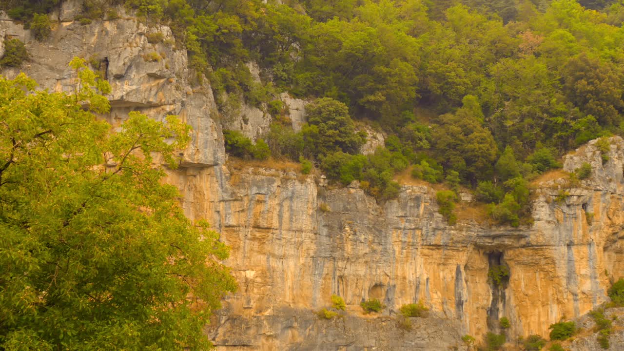 Scenic view of rocky terrain and green vegetation in Causses du Quercy UNESCO Geopark, France, under bright daylight