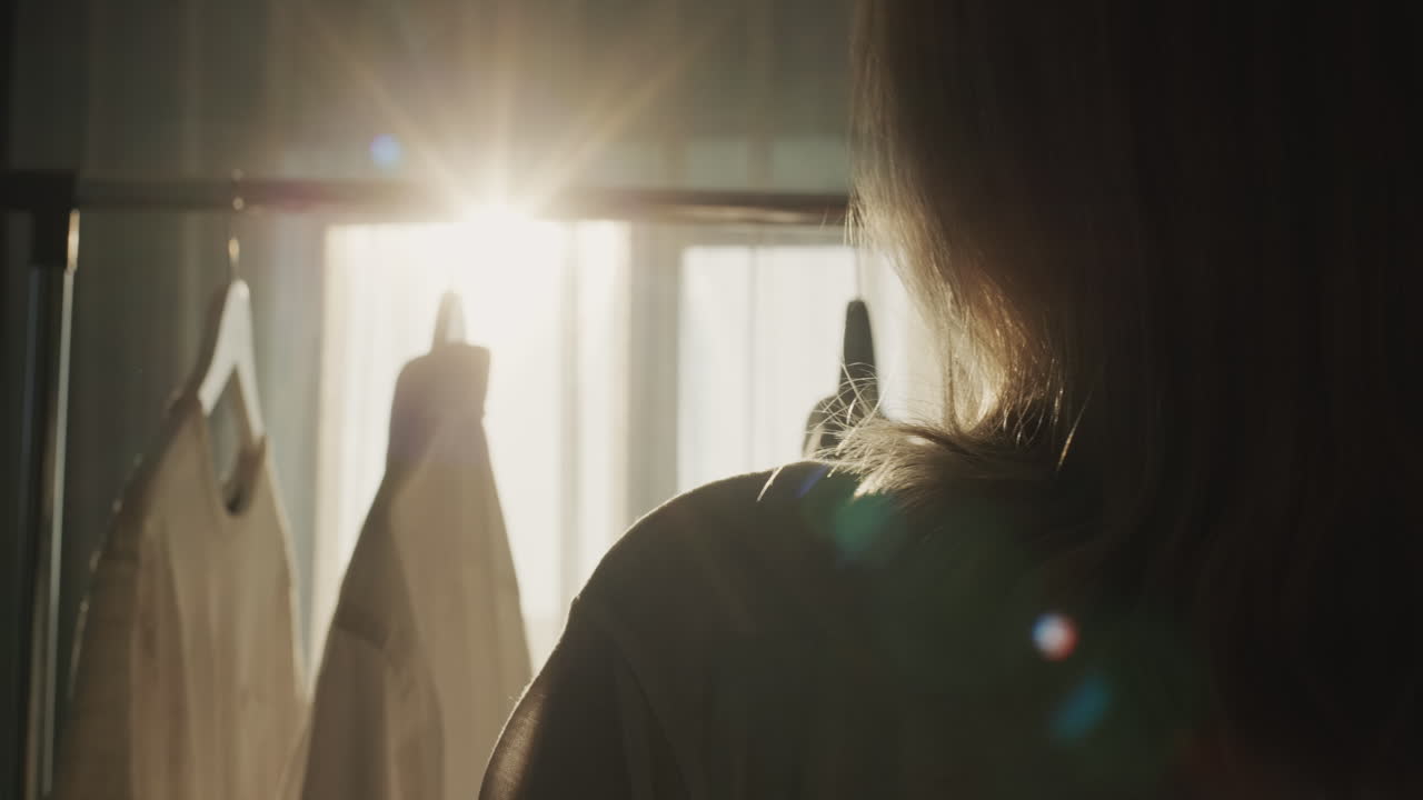 뒷면: 한 여자 가 옷 을 선반 에 매달고 있으며, 그 의 실루 ⁇  은 창문 에서 태양 을 아름답게 비추고 있다