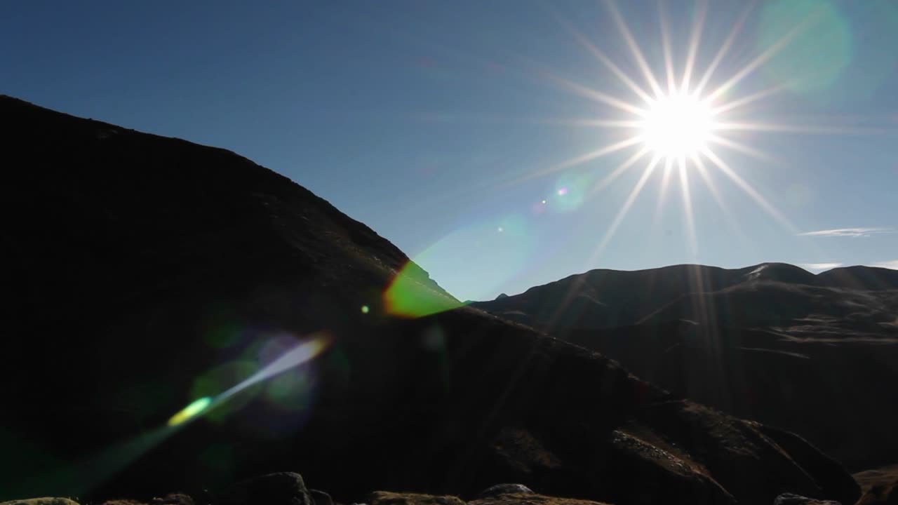 вспышка солнца со снежной вершиной на заднем плане