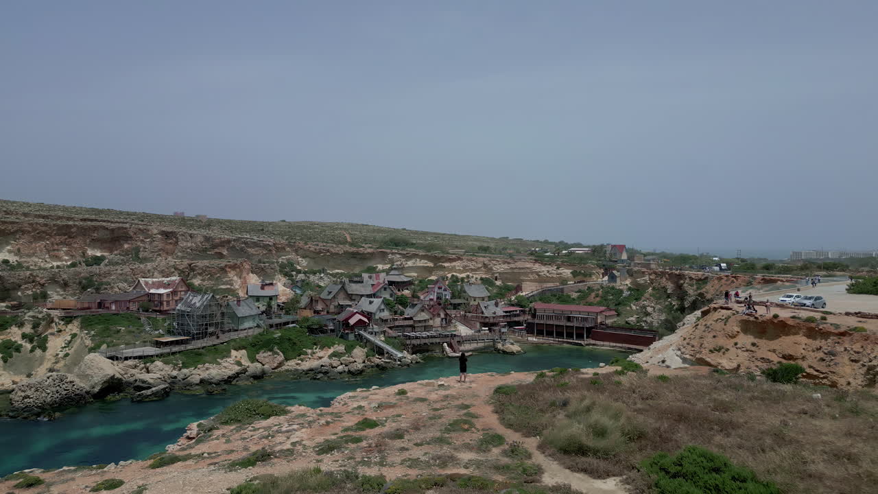 포피 마을, 멜리하, 몰타 - 공중 드론 앞으로 이동  ⁇   ⁇ 커 베이 지역, 멜리하, 몰타의 포피 마을 집 위에  ⁇ 빛 날