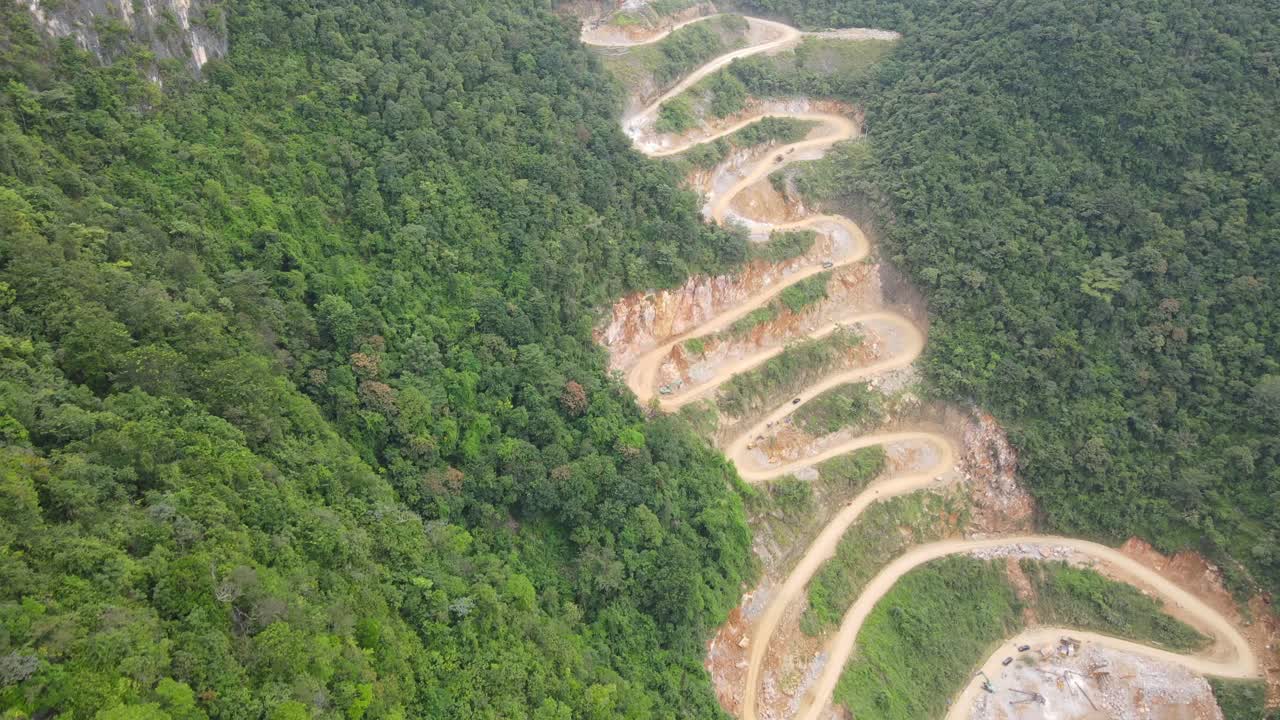 Drone move backward of zigzagged mountain pass in thick tropical jungle in Cao Bang Viet Nam
