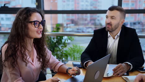 male boss drinking coffee while one of his employee talking. positive working atmosphere in modern office building. city view in blur at the backdrop.