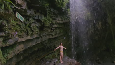 child standing under a waterfall in a natural cave