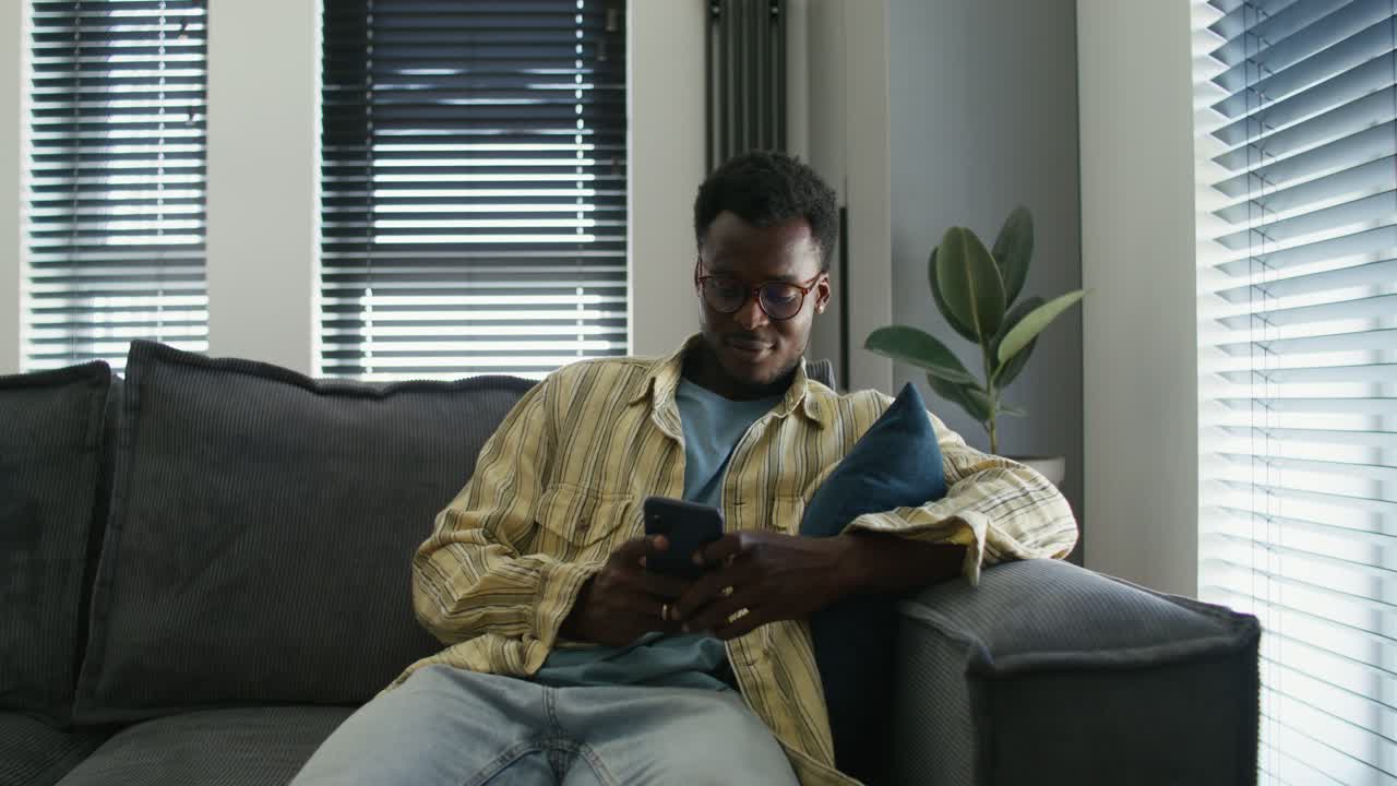 Man using smartphone on sofa