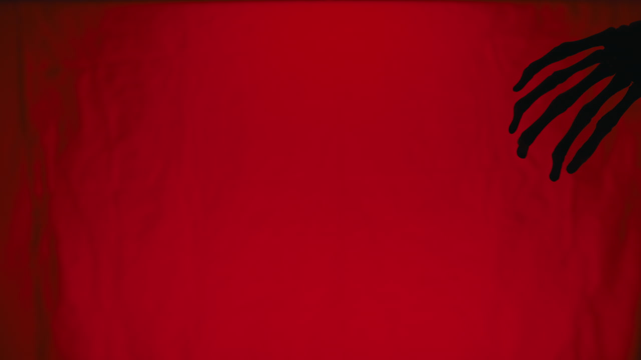 Silhouette of a hand on a red background Skeleton moves for Halloween