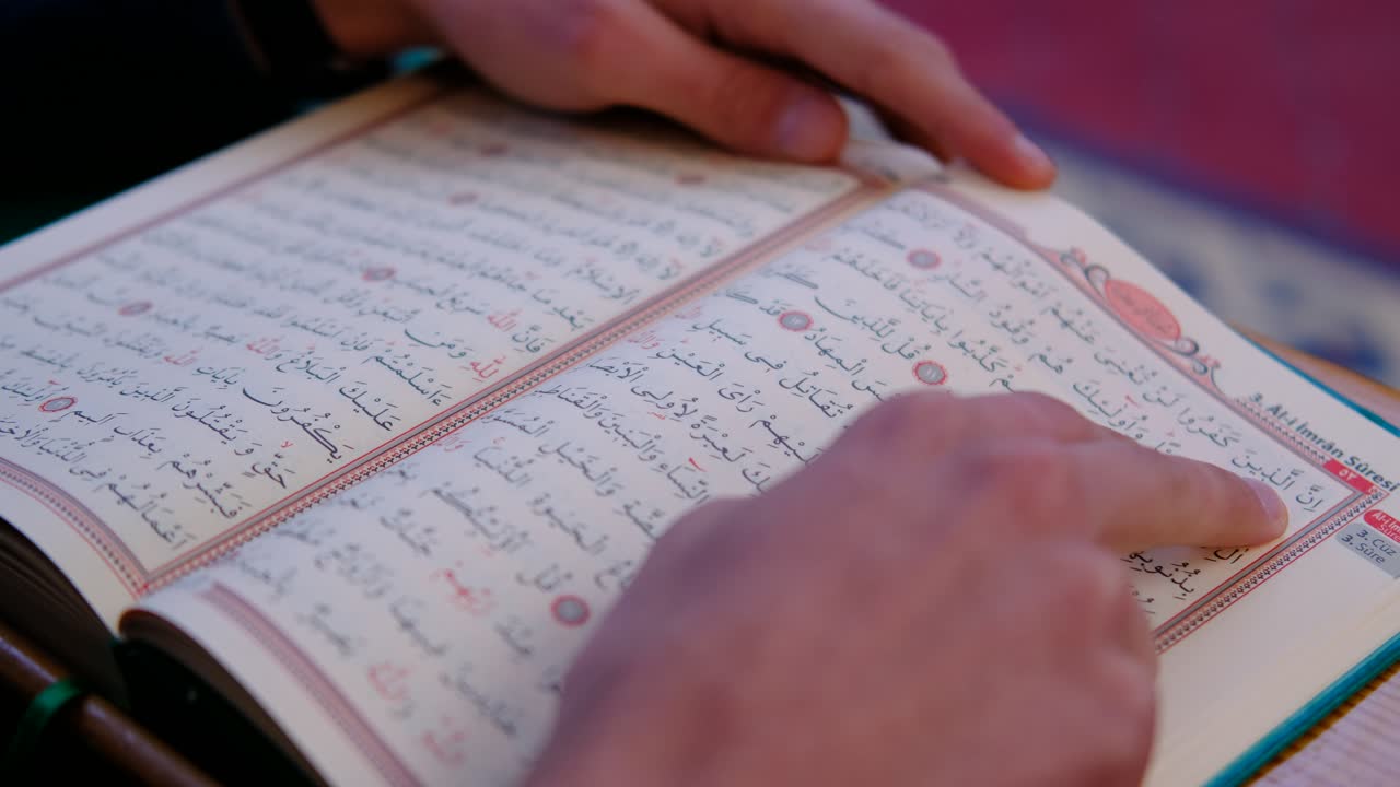 Primo piano di mani sul Corano in moschea 1