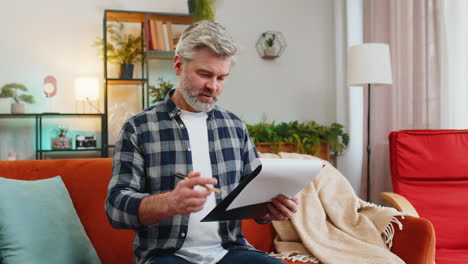 mature man with documents analyzing information reading business papers prepare financial report